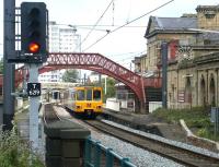 A Tyne & Wear Metro service, passes the closed station at Monkwearmouth in July 2004 on the northern approach to Sunderland. The 1848 station, originally built by the YN&B as a terminus, lost much of its importance in 1879 when the line crossed the River Wear to reach the centre of Sunderland. It closed in 1967 and is now an acclaimed museum. <br><br>[John Furnevel 10/07/2004]