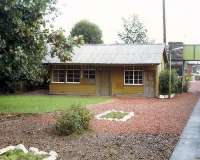 The former Invergarry and Fort Augustus Railway offices at Spean Bridge in 1988. The offices stood beside the old Fort Augustus bay platform on the left. At this date the building had been a post office. Today it has gone. View east with the main WHR building and signal box beyond the overbridge.<br><br>[Ewan Crawford //1988]