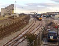 A container train being unloaded at the new facilities on the south side of Craiginches yard, Aberdeen on 21 February 2008. These replace the former container handling facilities at Guild Street, with other Guild Street traffic switching to Raiths Farm. On the north side of the main line is the Blue Circle cement terminal  <br><br>[Alan Cormack 21/02/2008]