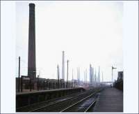 <I>Brick City</I>. Stewartby (originally Wootton Pillinge), Bedfordshire, on the Oxford - Bedford line in 1974. Built to house workers of the London Brick Co, with kilns and chimneys surrounding the station and dominating the landscape. At its peak, this enormous site boasted 167 chimneys and produced 16 million bricks per day. [Editor's note: The last bricks were made here on 29 Feb 2008 following a rundown by owners Hanson, due to failure to meet limits for sulphur dioxide emissions. The 4 remaining chimneys on the site are now listed structures.]<br><br>[Ian Dinmore 16/02/1974]