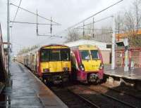 Scene at Hamilton West on 8 March 2008 with Milngavie bound 318 266 passing 334 015 destined for Motherwell.<br><br>[David Panton 08/03/2008]