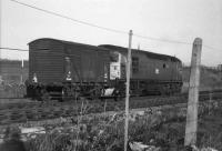 Second man detaching the solitary van from a class 26 which had arrived on the Saturday morning goods from Aberdeen in the <I>loop</I> outside the station goods yard. The <I>loop</I> had been constructed from the old roads from the passenger station to Aberdeen and St Combs.  The van in the picture has the words <I>sherry butts</I> chalked on its side, which perhaps suggests a recent trip to Speyside. (On busier trains it was great to watch the crew and Broch station staff gravity shunt the wagons and vans into the appropriate sidings in the yard).<br><br>[John Williamson //1972]