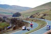 Not far from the former water troughs of Dillicar Common a First service heads south. An interesting comparison in investment at a fairly remote spot; two tracks versus one motorway comprising two roadways of four lanes each.<br><br>[Ewan Crawford 14/04/2008]