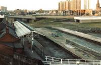 The north side of Manors station in 1982, showing the remains of through platforms 1 & 2 and bays 3-5. In the foreground is part of the long wooden footbridge that provided a link to the stations east platforms at that time. The new <I>blockhouse</I> building in the right background is the Tyne & Wear Metro and beyond that are the remains of New Bridge Street goods depot (originally Picton Street), former terminus of the Blyth & Tyne Railway, replaced in 1909 by Manors (North) on the extension to the junction with the ECML.<br><br>[Colin Alexander //1982]