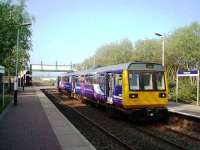 142036 bounces through Huncoat without stopping on its way to Colne. View across the level crossing towards Accrington. Huncoat Colliery, closed in 1968, was adjacent to the station.<br><br>[Mark Bartlett 08/05/2008]