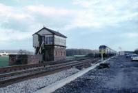 The new infrastructure for colour light signalling can be seen as D431 approaches Garstang & Catterall on a service for Scotland. The cars are parked in the old goods yard, which is now occupied by a feeder station for the 25kv power supply. The signal box closed in November 1972 with the commissioning of Preston power box. The station, behind the photographer, had only been closed for three years at this time but had already been demolished and cleared. <br><br>[Mark Bartlett //1972]