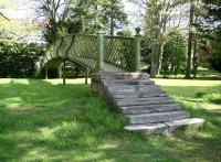 Shortly after leaving Peebles station for Galashiels, the Peebles Railway ran in a cutting, spanned by a footbridge, through what is now part of the grounds of the Peebles Hydro Hotel. Following closure of the line the cutting was filled in, but most of the footbridge remains. Part of the imposing frontage of the hotel can be seen through the trees in the left background in this view looking north over the old bridge on 18 May 2008. <a target=external href=https://canmore.org.uk/collection/1518736>A Canmore view of the bridge while in use</a>.<br><br>[John Furnevel 18/05/2008]