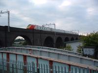 Railway crosses railway crosses canal. Top is the Bushbury Viaduct of the LNWR Stour Valley Line, below is the swing bridge of the GWR Wolverhampton Junction Railway (now re-used as a chord from Bushbury to Oxley) and below that is the Birmingham Canal Wolverhampton Level. View looks north west.<br><br>[Ewan Crawford 01/07/2003]