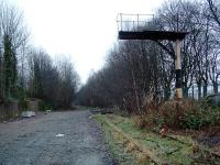 The signalpost still remained at the level crossing for some time after closure of the line. Some vegetation was removed in 2002 for construction of a new (or upgraded) sewer under the trackbed. Some panels were lifted out and not reinstated.<br><br>[Ewan Crawford 26/12/2002]