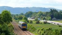 A Glasgow - Aberdeen hourly train passing Glencarse with the Antique Fair and Garden Centre with an excellent restaurant to the right of the A90 dual carriageway.<br><br>[Brian Forbes 10/06/2008]