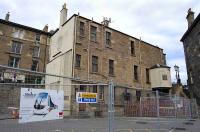 The <I>Caledonian Ale House</I> at Haymarket on 13 June, surrounded by fencing prior to demolition to make way for trams. Haymarket station stands to the right on the other side of the steps linking the car park and the station forecourt. The neighbouring <i>Ryries</i> had more luck! [See image 16520].<br><br>[Bill Roberton 13/06/2008]