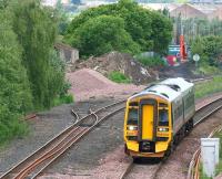 The 1055 departure from Bathgate on 30 June 2008, with the west end of the Bathgate car compound in the right background. The train has just passed a pile of rubble that is now all that remains of the former Rennies Bridge.<br><br>[James Young 30/06/2008]