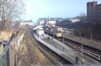 The <I>Rossendale Farewell</I> DMU Railtour in February 1981, marking final closure of the line to Rawtenstall, passes Bury Bolton Street, closed to passengers the previous year with the opening of Bury Interchange. However, the 1200v side contact third rails can still be seen. Nowadays the station is of course the bustling hub of the East Lancashire Railway. <br><br>[Mark Bartlett 14/02/1981]