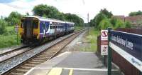 156490 heads south from Euxton Balshaw Lane station on 14 June 2008 with a service to Liverpool. The Class 156 has been adorned with NRM York vinyls. To the rear left of the unit is a <I>road type</I> warning sign indicating a signal in 221 yards. The signal, seen ahead of the train, controls access onto the two track section to Wigan at Balshaw Lane Junction.<br><br>[John McIntyre 14/06/2008]