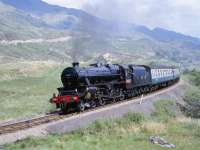 Black 5 5407 heading for Mallaig approaching the summit just west of Glenfinnan, heralding the return of steam to the West Highland line in May 1984. Unfortunately, apart from setting fire to much of the local heather that day, 5407 also managed to do the same to a section of S&T wiring, resulting in, amongst other things, the token having to travel by taxi and that nights sleeper departing some 3 hours late, arriving in London mid-morning.    <br><br>[Peter Todd 28/05/1984]