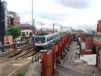 Metrolink tram 1012, on an Altrincham - Piccadilly service, drops off the Cheshire Lines formation onto the street-running section alongside the G-Mex/Manchester Central trainshed and undercroft.<br><br>[Mark Bartlett 07/07/2008]