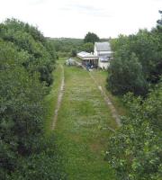 Looking east over thr the site of the former Whitstone and Bridgerule station towards Holsworthy on the line from Halwill Junction to Bude on 4 July 2008. It is now more than 40 years since trains ran on this line but the station building and platform canopy remain, now as part of a private house. The area between the platforms has been filled in and grassed over but the edge slabs are still clearly visible.<br><br>[John McIntyre 04/07/2008]