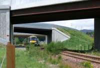 Southbound service passing under one of the two new flyovers at Ballinluig. To the right of the train the A9 dual carriageway can be seen which now has the national maximum speed limit of 70mph.<br><br>[Brian Forbes 15/07/2008]