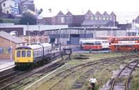 The west side of Whitehaven station looking south from Bransty signal box in 1987 with a terminated service from Carlisle standing at the buffer stops alongside the (relatively) new station building. On the east side of the station is a through platform with the line south towards Barrow entering a 1 kilometre long tunnel immediately after leaving the station. The former goods yard to the right now houses a Tesco Superstore.    <br><br>[Ian Dinmore //1987]