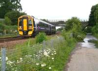 Looking north along the trackbed of the former South Queensferry branch at Dalmeny North Junction in June 2008 as a 158 for Waverley passes on the main line running down from the Forth Bridge.<br><br>[John Furnevel 26/06/2008]