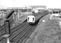 The 11.35 Glasgow Central - Stranraer service passing through Newton - on - Ayr station in April 1978. Falkland Yard is in the background and the line off to the left runs to Ayr Harbour.<br><br>[John Furnevel 07/04/1978]