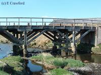 Looking north at the somewhat dilapidated wooden trestle bridge by Fordmouth Brickworks. It had only been used for farm traffic after closure of the line but was to be used again as the railway to Greenburn re-opened.<br><br>[Ewan Crawford //]