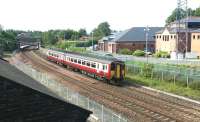 A Glasgow Central - Carlisle DMU south of Dumfries station in May 2003. The building on the right is the headquarters of Dumfries and Galloway Police, standing on the site once occupied by Dumfries locomotive shed. [See image 45214]<br><br>[John Furnevel 11/05/2003]