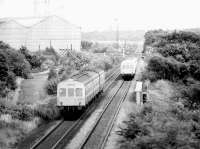 DMUs meet at Gartcosh in 1980. The rolling mill and sidings are on the left, Gartcosh Junction and signal box can just be seen in the background above the train on the right. This is the approximate site of the new Gartcosh station opened on 9 May 2005. [See image 16718]<br><br>[John Furnevel 02/05/1980]