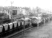 A loaded coal train passing a slab train from Lackenby at the north end of Millerhill Yard in 1997. Both trains are hauled by class 56 locomotives. The EWS example on the coal train is unidentified, while the approaching Loadhaul liveried unit is 56045.  <br><br>[John Furnevel 03/11/1997]