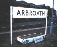 These BR enamel signs were of course usually white on pale blue, but, probably in a half-hearted attempt to bring it into the post-1964 British Rail image, this one was overpainted in black on white, though retaining the original Gill Sans lettering.  It was well done and the result was strikingly clear, and as far as I know unique to Arbroath.<br>
<br>
The state of the platform and and general air of decay would not be <br>
acceptable today!<br><br>[David Panton /08/1985]