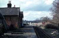 The Midland and Great Northern railway architecture was very characteristic and attractive. At the time of this photo, in February 1977, Lenwade was the last example of a fully equipped M&GN station that was substantially intact and still operational for goods. One hoped that when regular freight traffic petered out at the end of 1981, some serious preservation attempt would be made. What one got initially included a stockade built round the station, <I>Keep Out</I> notices and a vicious sounding dog to guard it. Although the trackwork and accessories have now largely gone, the building and platform still remain alongside <I>Marriotts Way</I>.<br><br>[Mark Dufton 13/02/1977]