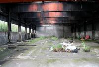 Looking through the gap between the metal gates into the old Bathgate locomotive shed on 31 July 2008, with track still visible on the left. The old shed had been vacated fairly recently, pending its forthcoming demolition, after many years of use by a building firm following its disposal by British Railways in 1964. I swear I could still detect a slight whiff of that evocative mixture of steam, grease, coal and..... I think I need a holiday... <br><br>[John Furnevel 31/07/2008]