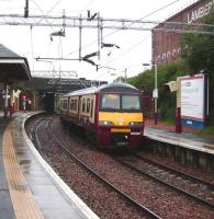 320 320 arrives at Coatbridge Sunnyside with an Airdrie train on a wet 18 August 2007.<br><br>[David Panton 18/08/2007]