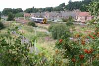 An eastbound service from Bathgate approaching Boghall on 14 August 2008 runs past the site of Bathgate East Junction. A branch turned  south at this point, passing under the A7066 road (behind the camera), and running to Seafield Oil Works east of Blackburn. The walkers on the left of the picture are on the trackbed of the former branch which closed in 1955. [See image 20274]<br><br>[John Furnevel 14/08/2008]