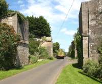 A tractor takes a load of hay bales into Roxburgh from the west in July 2008, passing the remaining abutments of the twin railway bridges that once carried traffic leaving the south end of the former Roxburgh station, located off picture to the left.<br><br>[John Furnevel 01/07/2008]