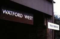 Station with an identity crisis! There is not, and has never been a station called West Watford.... notwithstanding this photograph, taken in June 1985, which is presumably the result of a sign maker having an off day. The station at Watford West was opened on 15 June 1912 along with the rest of the Croxley Green branch. The branch was <I>temporarily</I> (but definitely not <I>officially</I>) closed in 1996 (due primarily to the significant legal difficulties  involved in permanently closing a railway station). The minimum legal requirement to maintain <I>open</I> status is one service per month in one direction - which is provided in this case by a <I>temporary</I> replacement bus service. In 2005/6 there were 10 passengers (or the same passenger 10 times) recorded as having bought tickets to Watford West. On a more positive note, LU has plans to divert the Metropolitan Line from its current terminus at Watford to Watford Junction. This would mean bringing most of the Croxley Green branch back into use (not that its actually closed you understand) and would result in Watford West station being completely rebuilt and reopened (or rather, <I>not temporarily closed</I> any more....) <br>
<br><br>[David Panton 28/06/1985]