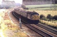 Blackpool Bank Holiday traffic between Salwick and Kirkham with 40097 westbound on a passenger train on a very hot August day. 40097 was withdrawn in June the following year and cut up at Doncaster by March 1984. Map ref SD 448324 - Salwick station can just be seen in the distance.<br><br>[Mark Bartlett 28/08/1982]