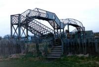 The former station footbridge at Elliot Junction in March 1999. Access to the island platform was via steps from the now blanked off central section of the bridge. Notice the structure comprises 2 standard decks, but in different styles.<br><br>[David Panton 15/03/1999]