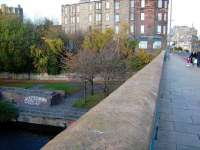View over the Water of Leith looking Northwest along Great Junction Street in November 2007. Down below on the left stood the platforms of Junction Bridge station, opened by the Edinburgh, Leith and Newhaven Railway in 1846 as Junction Road and, following the name change in 1923, eventually closed in 1947. The station booking office stood on the same level as the road bridge with the entrance straight ahead on the left. After passing below the bridge the line entered a tunnel under Coburg Street, off to the right, before emerging at North Leith terminus (also unofficially known as Leith Citadel) on Commercial Street. <br>
<br><br>[David Panton 17/11/2007]