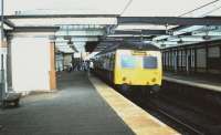 An Ayr - Glasgow Central service arrives at Troon in June 1985, with electrification equipment installed but not yet live. <br><br>[David Panton 12/06/1985]