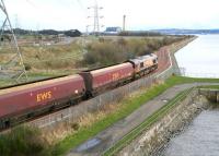 EWS 66083 passes below Kincardine Bridge on 5 April 2008, hauling the first coal train from Hunterston Import Terminal to use the newly reopened line between Stirling and Longannet power station. In the right background a freighter standing off Longannet Point is about to enter Grangemouth docks.<br><br>[John Furnevel 05/04/2008]