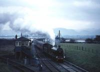On an overcast March day in 1964, with snow on the Ochil Hills, ex-NBR 256 <I>Glen Douglas</I> brings the Scottish Rambler No 3 railtour south over Alloa swing bridge into Throsk. In the foreground is the line to the former Royal Naval Armament Depot at Bandeath, now an industrial estate and general storage complex.<br><br>[Robin Barbour Collection (Courtesy Bruce McCartney) 30/03/1964]