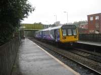 Derker station opened in 1985 on a new site. It effectively replaced nearby Royton Junction, which closed two years later. 142003 calls at the simple wooden platform on a stopping service from Shaw and Crompton to Manchester Victoria.<br><br>[John McIntyre 30/09/2008]