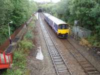 Trains leaving Oldham Werneth for Manchester would bear left slightly to gain the formation of the 1880 line through Failsworth to Thorpes Bridge Junction. Straight on led to the infamous 1:27 Werneth incline down to Middleton Junction. 150135 leaves Werneth on a stopping service to Manchester Victoria in this view eastwards showing Werneth Tunnel and immediately beyond it Oldham Central Tunnel. Oldham Werneth closed in 2009 and platforms have been removed. [See image 21183] for the view from the other side of this overbridge. <br><br>[Mark Bartlett 30/09/2008]