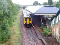 156461 is Manchester bound at Atherton viewed from the road overbridge.  The staircase leading to the booking office can also be seen in this view as can the formation of the second line but the old platform is covered by trees. At the time of our visit the overall roof on the island platform was being painted underneath. <br><br>[John McIntyre 30/09/2008]