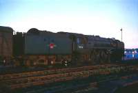 Britannia Pacific 70016 <I>Ariel</I> (minus nameplates) stands at Stranraer Harbour in the mid 1960s under a low sun. The locomotive, built at Crewe in 1951, arrived at Kingmoor in early 1965 where she spent her last years prior to withdrawal in August 1967.<br><br>[Robin Barbour Collection (Courtesy Bruce McCartney) //]