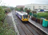 A turnback siding was created at Shaw alongside the singled track to Rochdale. With the departure of the Rochdale service and the fast train to Manchester 142060 has dropped back over the crossover into the station ready to form a stopping service to Manchester Victoria. This passing and reversal operation was performed every half hour during the day time until the line closed for Metrolink conversion in 2009. [See image 21124] for a 1970s view of the station.<br><br>[Mark Bartlett 30/09/2008]