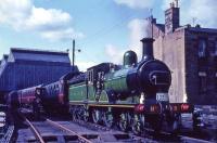 <I>Gordon Highlander</I> at Leith Central in 1965 with Scottish Rambler No 4. The train is straddling the bridge over Easter Road, constructed in 1901 after demolition of the central section of the 4-storey tenement block behind the locomotive, in order to give access to the new station. The gap has since been refilled by a new 5-storey central section [see image 10105].<br><br>[G W Robin 19/04/1965]