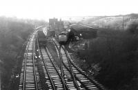 Narrow gauge interchange alongside Gathurst station in November 1978 with 25105, on a pick up freight, shunting gunpowder vans in a frosty Gathurst yard while the coal empties from Southport stand on the running line. The yard was linked by a narrow gauge railway that crossed the Douglas Valley on a steel viaduct (off to the right), to a nearby Nobel's explosives factory. [See image 21337]. The Industrial Railway Society 1973 handbook shows a fleet of six 4wDM Ruston gauge locos were based here and some narrow gauge wagons can be seen outside the transhipment shed. One of these wagons is being reconstructed by the Moseley Railway Trust in Staffordshire to work alongside one of the Gathurst Rustons, No.7, also preserved there. Gathurst station can still be seen from the M6 motorway viaduct in the background but the yard and narrow gauge line are no more. <br><br>[Mark Bartlett 28/11/1978]