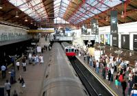 <I>Barking anyone..?  ...just about!</I> Scene at Earls Court District line station in June 2004 looking east towards the main entrance on Earls Court Road with an Ealing Broadway train arriving at platform 3 alongside a service to Edgware Road that has just been signalled out of platform 2.<br><br>[John Furnevel 16/06/2004]